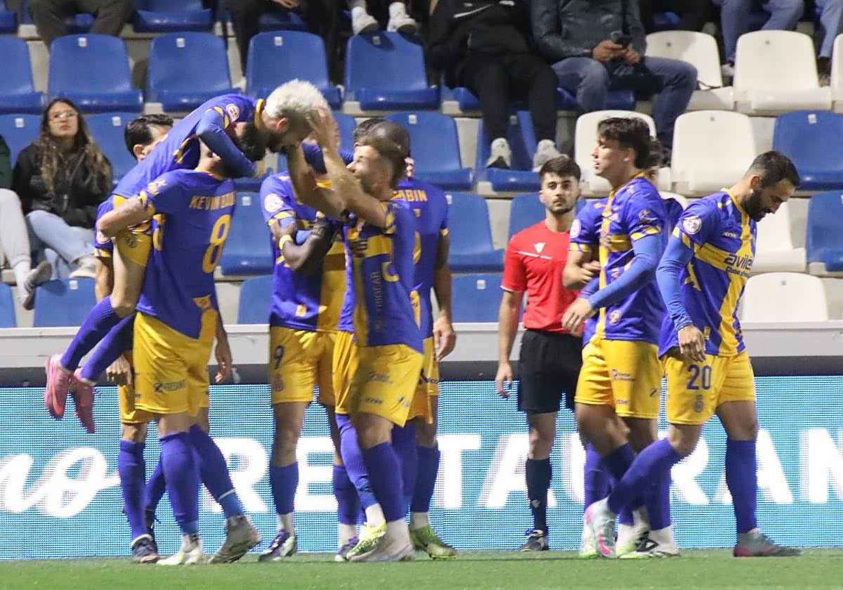 Kevin Bautista eleva en brazos a Isi Ros tras su segundo tanto, con el murciano siendo felicitado por Berto Cayarga.