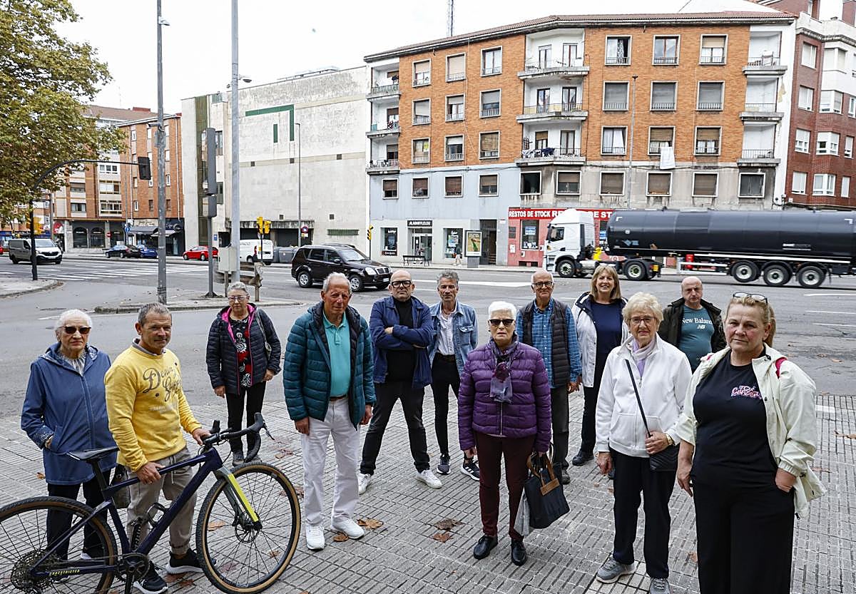 Los vecinos de La Calzada posan para EL COMERCIO en Cuatro Caminos. Al fondo, uno de los miles que pasan a diario.