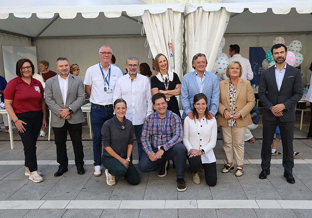 Los representantes de colegios profesionales y asociaciones con la concejala Lourdes García, de rodillas en el centro.
