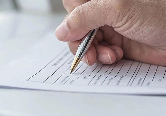 Una persona rellenando un formulario.