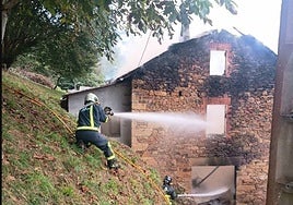 Los bomberos sofocan las llamas que arrasaron parte de la vivienda.