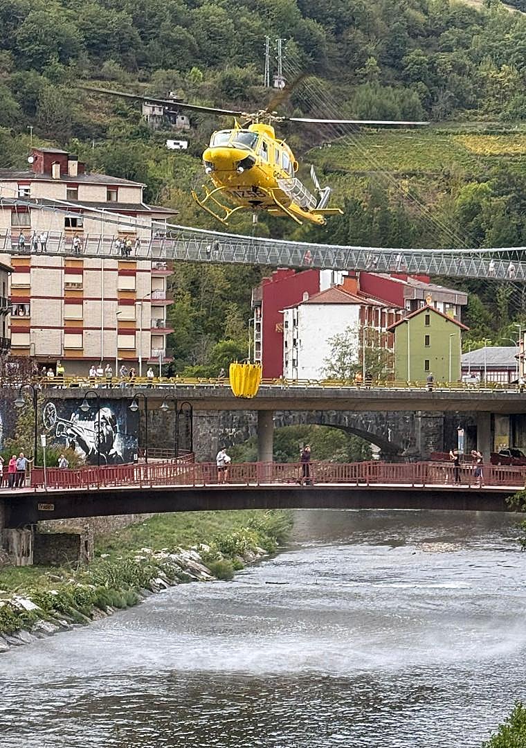 Imagen - El helicóptero cogiendo agua para sofocar el fuego.