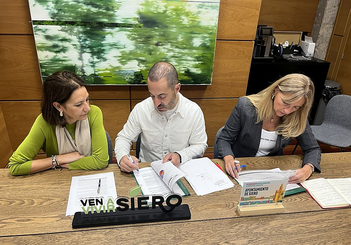 Ángel García, 'Cepi', y Alejandra Cuadriello firman el acuerdo presupuestario ante la mirada de la edil Patricia Antuña (izquierda).
