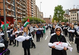 Manifestantes cargan bultos que simulan ser cuerpos de niños asesinados en Gaza.