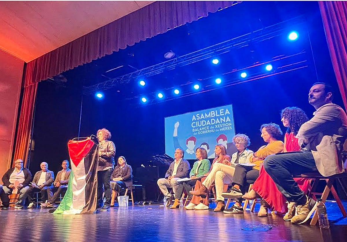 La coordinadora de IU de Mieres se dirige a los vecinos con el equipo de gobierno en el escenario de la casa de la Cultura