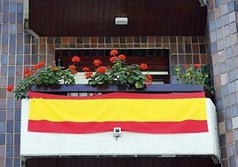 Un balcón luciendo la bandera de España.