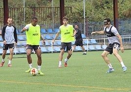 Quicala Bari, que podría volver a ser titular en el Ruta de la Plata, pasa el balón presionado por Adri Gómez, con Macías detrás.