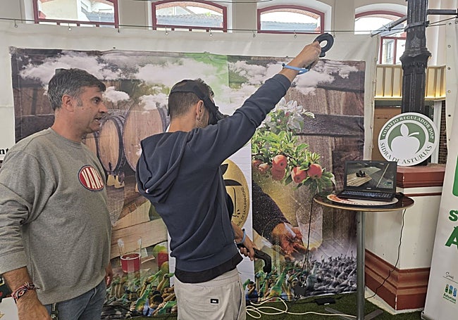 Un joven aprende a escanciar en el puesto de la DOP Sidra de Asturias.