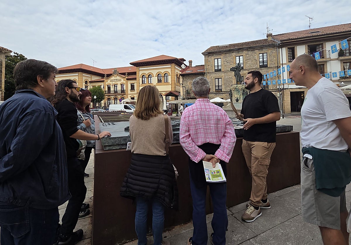 El grupo que participó en la visita ante la maqueta que recrea la Villaviciosa antigua y ante la estatua de 'La manzanera'.