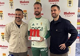Aarón Escandell, en el centro de la imagen, posa con el trofeo que lo acredita como mejor jugador del Real Oviedo de septiembre.
