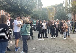 Los vecinos concentrados delante del portal de El Entrego donde se produjo la okupación.