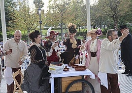 Participantes en el concurso de vestimenta de época brindan en el paseo del Bombé.