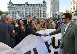 El presidente de Asturias, Adrián Barbón, saludando a quienes portaban la pancarta contra el peaje del Huerna, el pasado viernes.