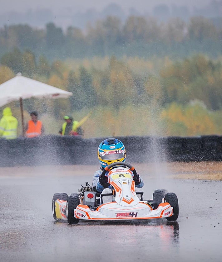 Imagen secundaria 2 - Neizan Granda, junto a su equipo y en dos momentos de la carrera final sobre lluvia en León.