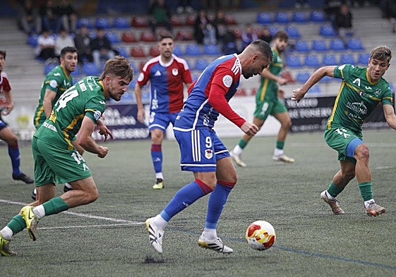 El delantero Miguel Ángel Guerrero, rodeado de rivales, protege el esférico.