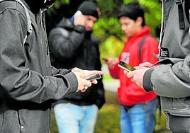 Un grupo de jóvenes inmersos en sus dispositivos móviles, sin interactuar entre ellos.