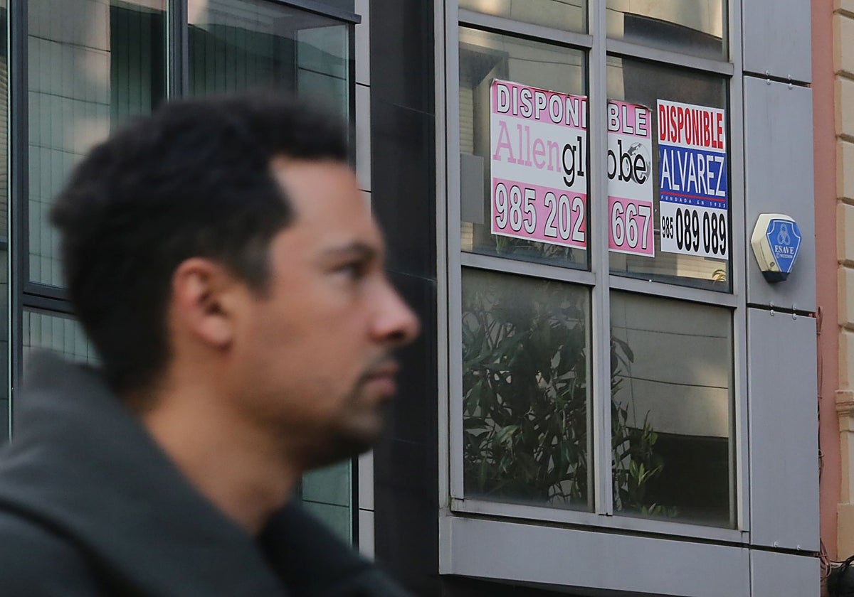 Un ciudadano camina delante de un piso en alquiler, en Oviedo.