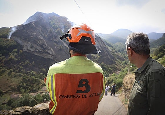 Un bombero y un agente del medio natural vigilan un incendio, en Somiedo, el pasado agosto.
