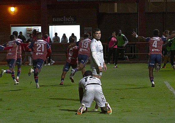 Los jugadores del Real Ávila celebran el gol de la victoria, con Eze arrodillado sobre el terreno de juego y Raúl Rubio mirando hacia atrás.