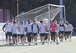 Los jugadores del Real Avilés mueven una portería durante un entrenamiento de esta semana en La Toba 2.