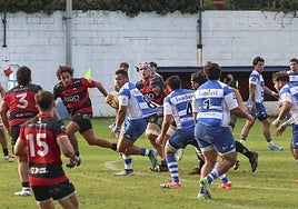 El segunda-tercera línea del Pasek Belenos, Bernie, trata de avanzar con el oval sujetado de la camiseta por un rival.