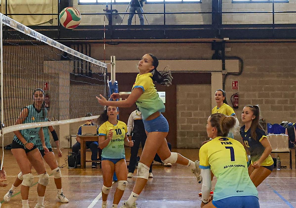 Una jugadora del Fertiberia Los Campos ejecuta un remate, con Natalia Peña y Sandra Iglesias pendientes del balón.