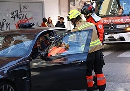 Los bomberos colocan un collarín al herido en el interior de su coche.