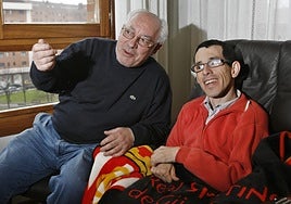 Alfredo Tejedor con su hijo Fredi, aquejado de parálisis cerebral, y entre ambos el escudo del Sporting en una imagen de 2012.