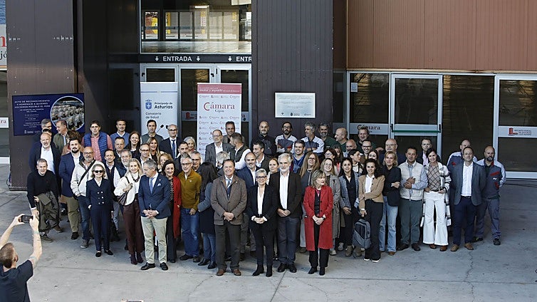 Foto de familia de los asistentes al acto de reconocimiento y agradecimiento a todos los profesionales implicados en el hospital provisional H144, instalado en el pabellón central del recinto ferial Luis Adaro de Gijón durante la pandemia de la covid-19. Desde hoy, una placa recuerda al personal que lo hizo posible y a los 334 pacientes que fueron atendidos en él.