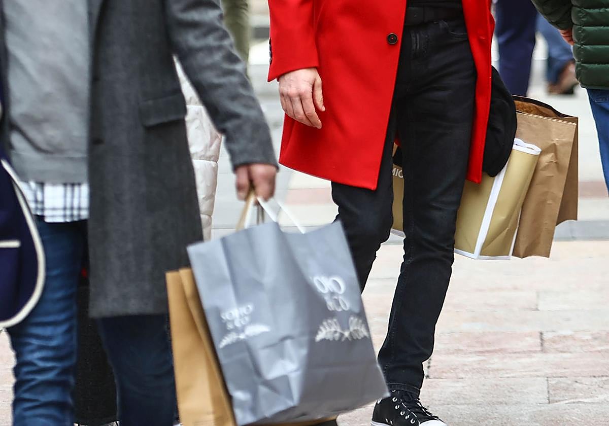 Personas portando sus compras por las calles de Oviedo.