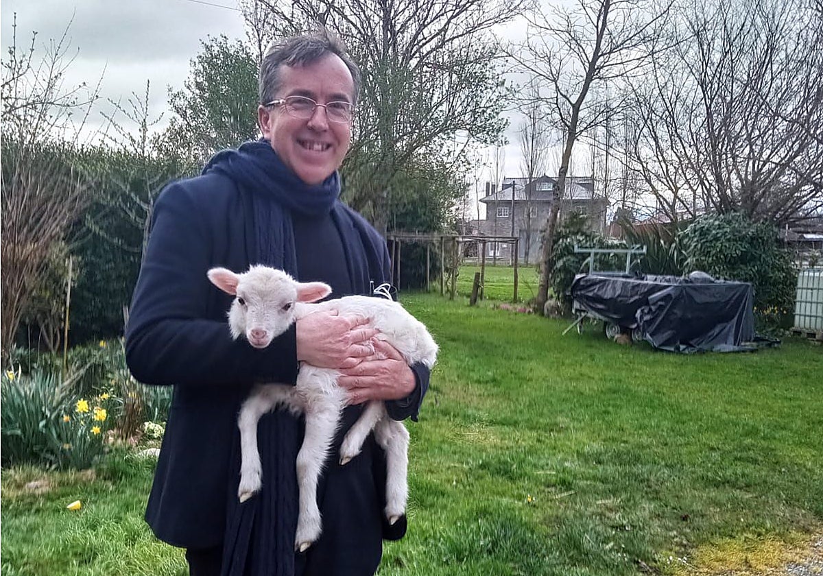 El sacerdote con un cordero en una de las aldeas donde ejerce.