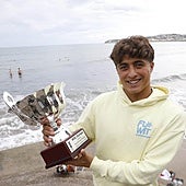 Alfonso Suárez posa con la copa de campeón europeo con el oleaje de San Lorenzo de fondo.