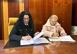 Vanessa Gutiérrez y Amparo Antuña, firmando el convenio.