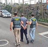 El detenido, custodiado por dos guardia civiles en el acuartelamiento de Gijón.