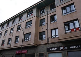 Trapos rojos en las ventanas de un edificio de la calle de Mariano Pola, en Gijón.