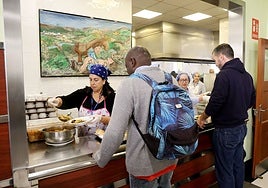 El personal de la Cocina Económica de Oviedo atiende a los usuarios del comedor benéfico, que comenzará a dar desayunos a partir de enero.
