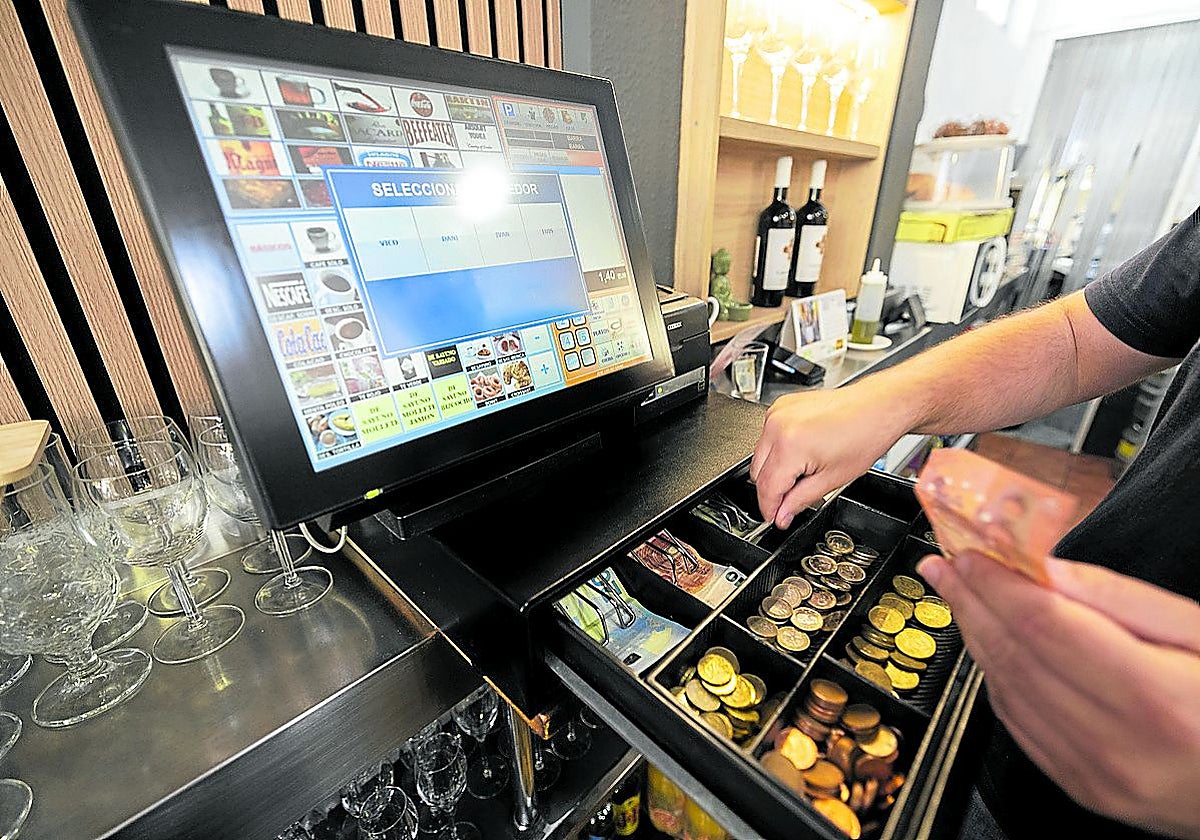 Cobro en una caja registradora de última generación en un establecimiento.