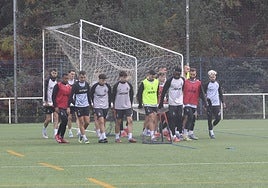 Parte de la plantilla del Real Avilés desplaza una portería portátil en un entrenamiento de esta semana en La Toba.