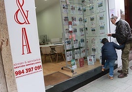 Un hombre mira anuncios de venta y alquiler de viviendas en una inmobiliaria del centro de la ciudad.