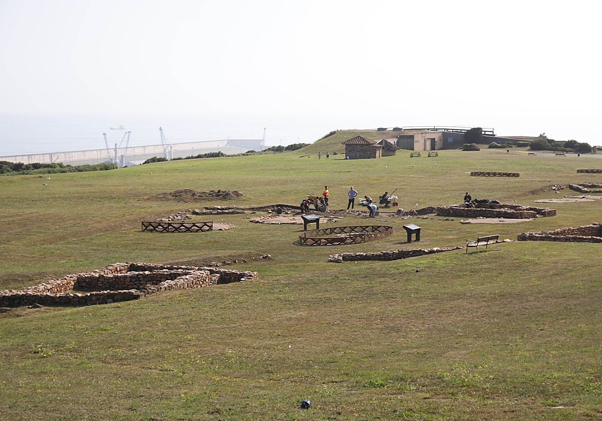 La zona del yacimiento conocida como La Llanada, con construcciones de época astur y romana. Al fondo, el Museo de la Campa Torres.