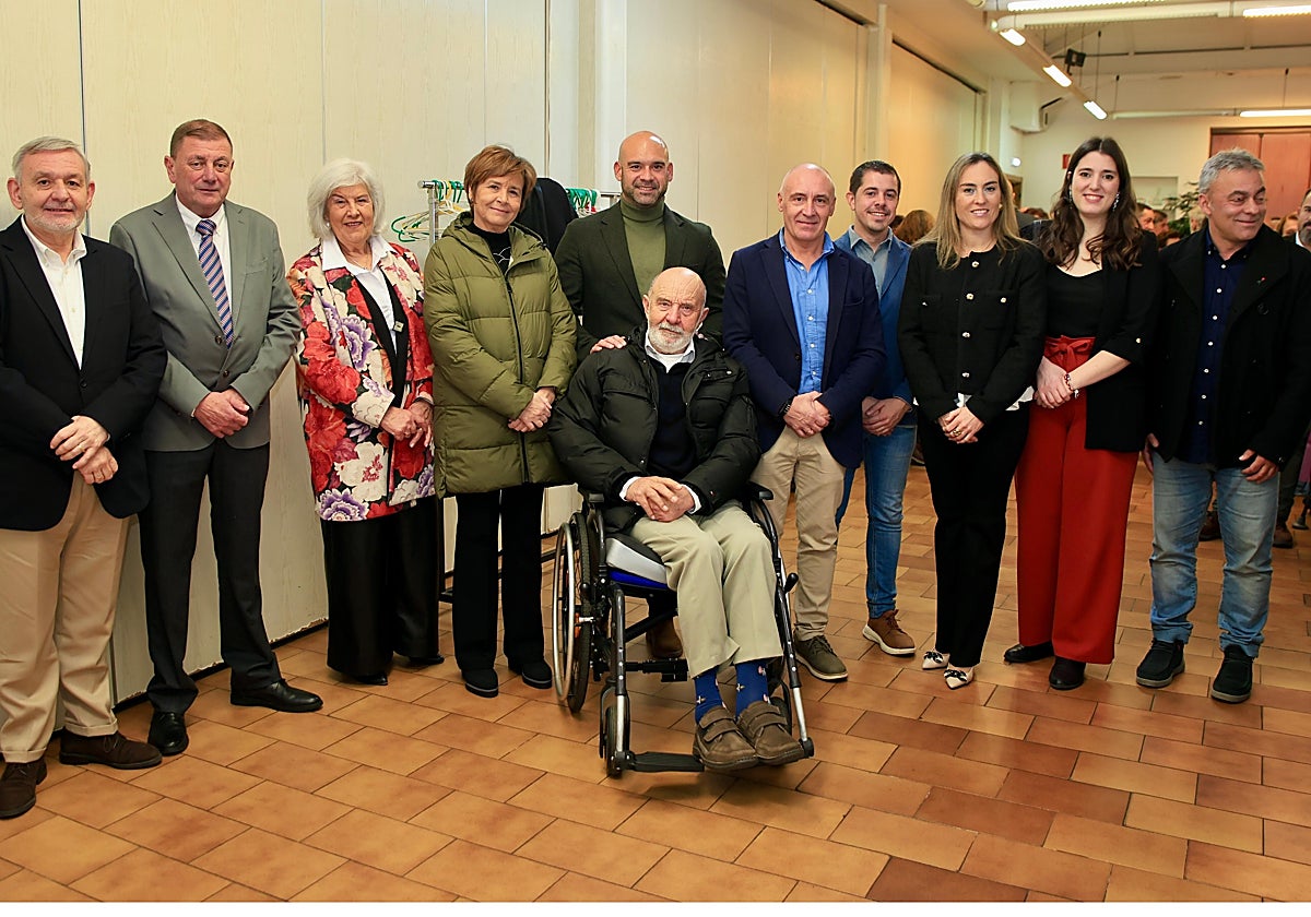José Luis Pérez, en silla de ruedas en el centro, rodeado de su mujer Mina, la alcaldesa, José Ramón Fiaño (Caja Rural de Gijón), Miguel Llanos (presidente de Les Caseríes) y representantes de todos los grupos políticos municipales salvo Vox.