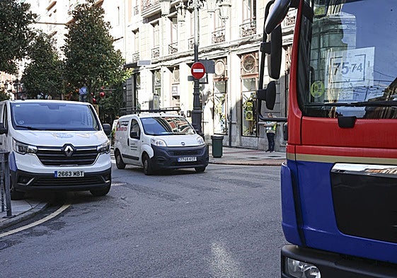 Furgonetas y un camión de reparto en el centro.