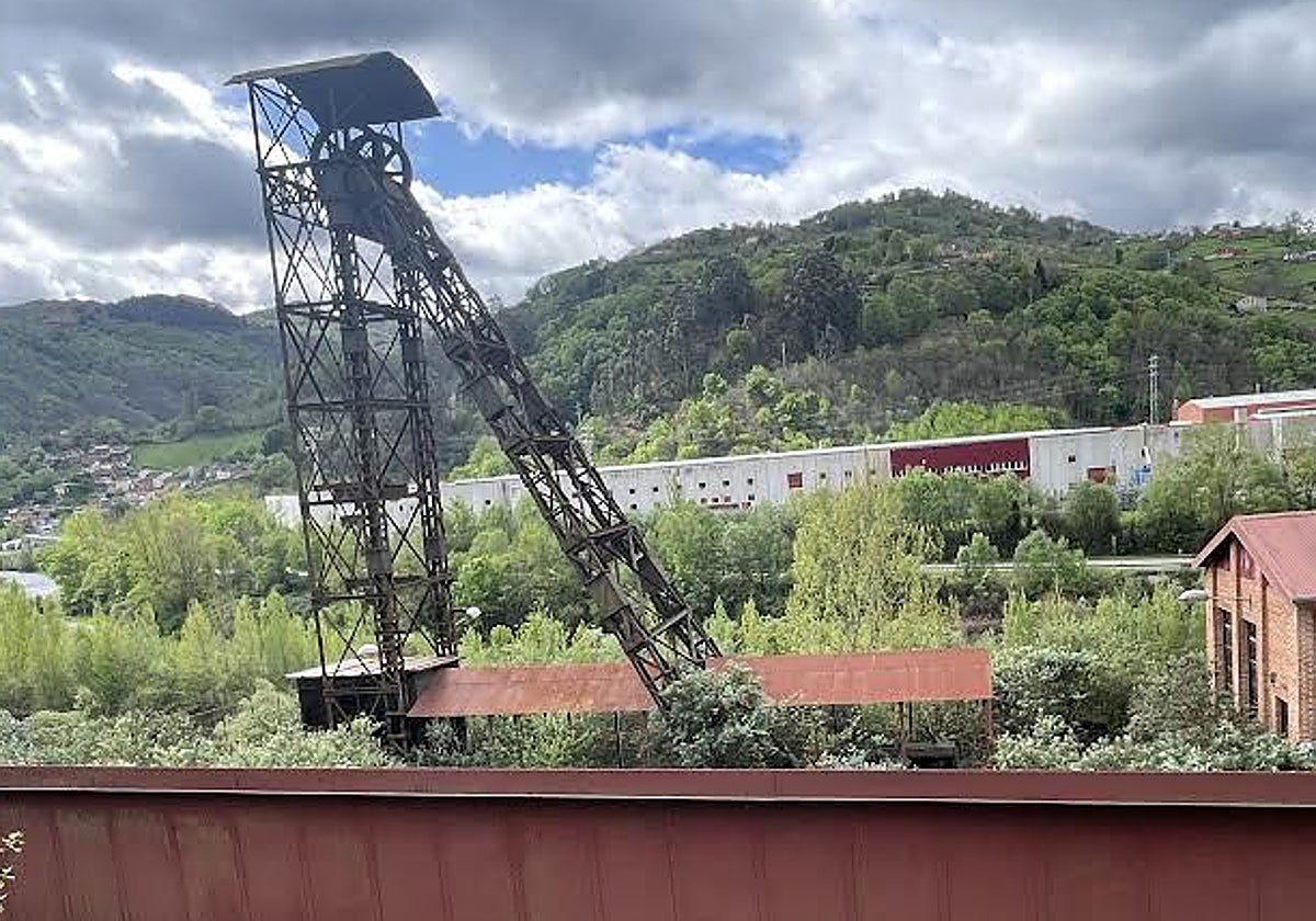 El castillete del pozo San Vicente, a sus pies la estructura que serviría para adecuar un ascensor o una vieja locomotora.