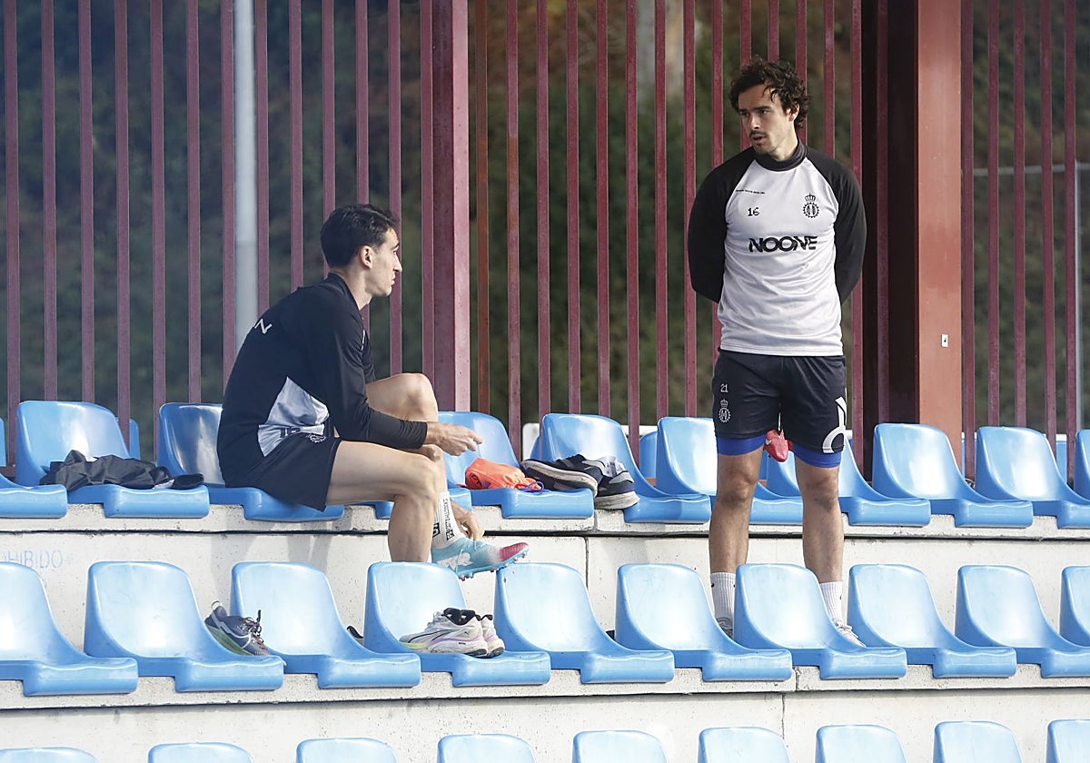 Pelayo Suárez, a la derecha, en la grada de La Toba junto a Adri Gómez en el entrenamiento de este miércoles del Real Avilés.