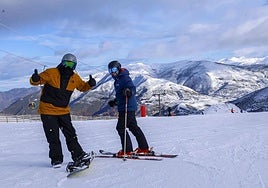Dos usuarios disfutan del primer día de la temporada de esquí en la estación de Valgrande-Pajares.