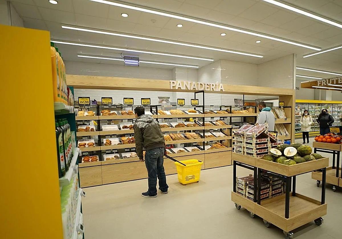 Algunas personas en la sección de panadería de un Alimerka.