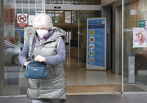Una paciente sale con mascarilla del centro de salud Puerta La Villa de Gijón.