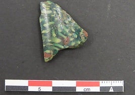 Fragmento de vidrio mosaico de tonalidad verde oscura hallado en la Campa Torres, en Gijón.