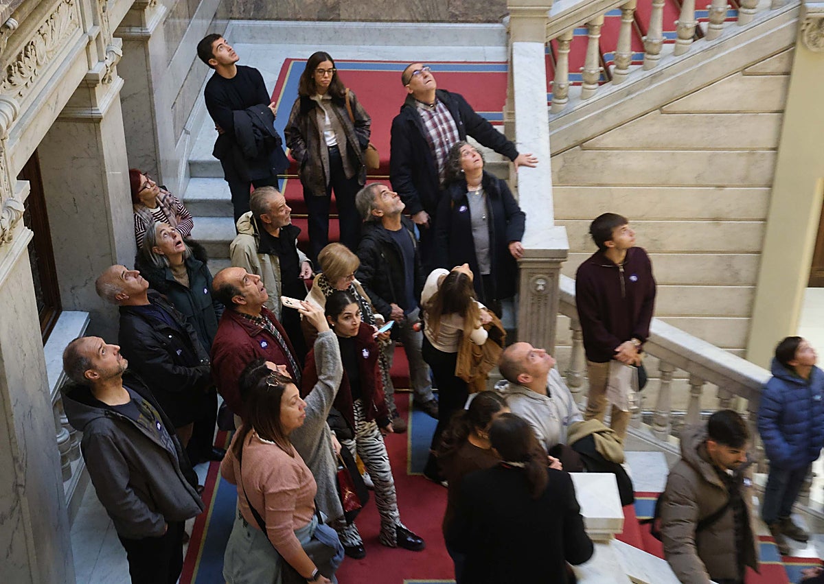 Imagen secundaria 1 - En la primera foto, el Adrián Barbón canario. En la segunda, los visitantes en la escalera imperial, mirando hacia las vidrieras. En la tercera, Elisa Martínez, junto al traje y las mazas de los maceros.