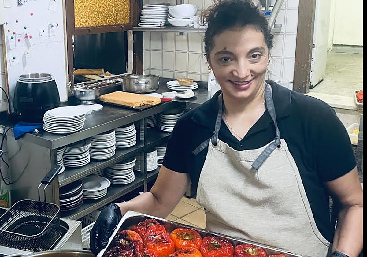 La cocinera del restaurante San Mamés con una bandeja de apetitosos pimientos rellenos.